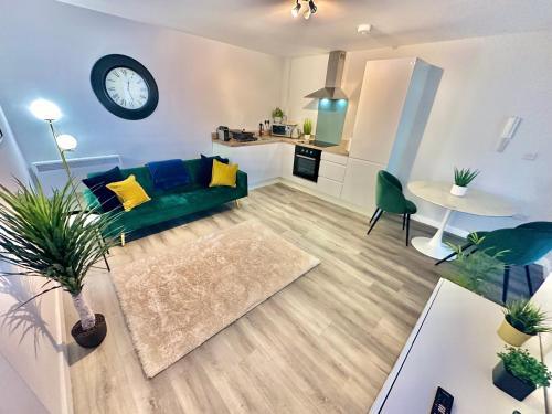 a living room with a green couch and a kitchen at Sleek Urban Getaway - With Parking in Bournemouth