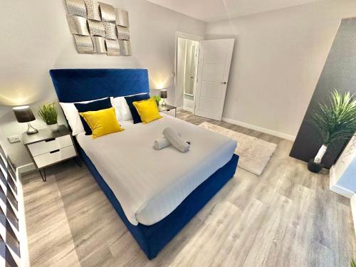 a large bed with a blue headboard in a bedroom at Sleek Urban Getaway - With Parking in Bournemouth