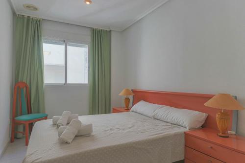 ein Schlafzimmer mit einem Bett, einem Stuhl und einem Fenster in der Unterkunft 004 - Club Náutico 001 - comfortHOLIDAYS in Santa Pola
