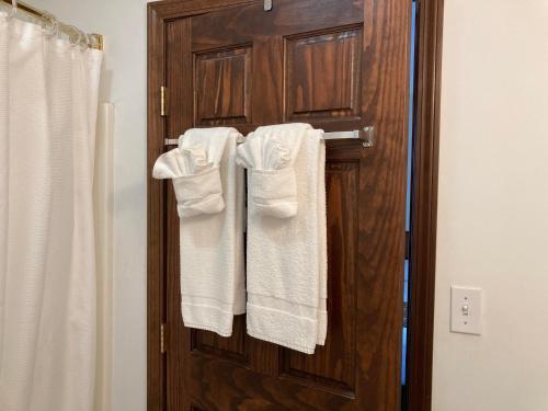 a bathroom with white towels hanging on a wooden door at The Hotel Pratt in Cooperstown