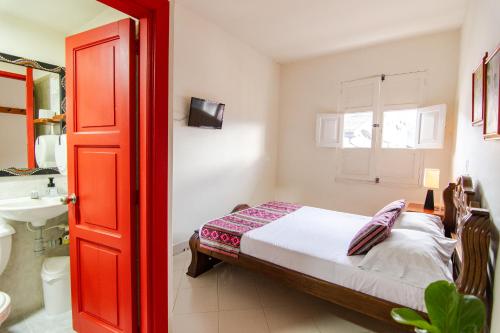 a bedroom with a bed and a sink and a red door at Hotel Casa Grande in Jardin