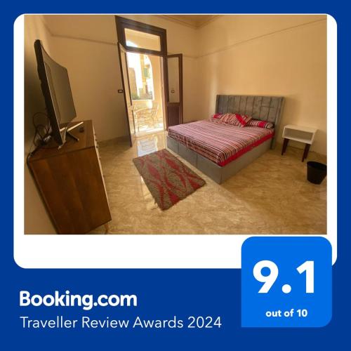 a bedroom with a bed and a tv on a dresser at Comfy private room with big sunny balcony near cairo airport مكان مودرن للاقامة دقائق من مطار القاهرة الدولى in Cairo