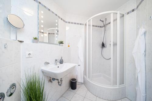 uma casa de banho branca com um lavatório e um chuveiro em LaDolceVita - 100m2 Apartment in Zentraler Lage em Olching