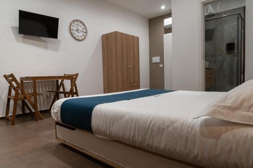 a bedroom with a bed and a clock on the wall at suite 18 luxury apartments in Bari
