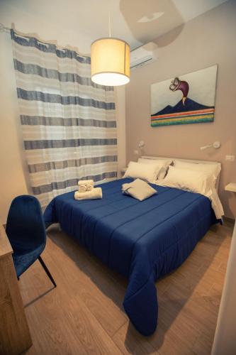 een slaapkamer met een blauw bed en een blauwe stoel bij B&B Zelia Napoli in Napels