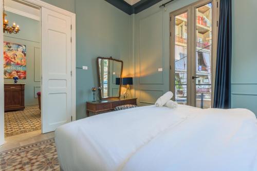 a bedroom with a white bed and a mirror at 961 Station Apartments in Mar Mikhael in Beirut