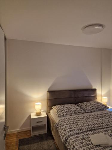 1 dormitorio con cama y mesita de noche con lámpara en Nika en Banja Luka