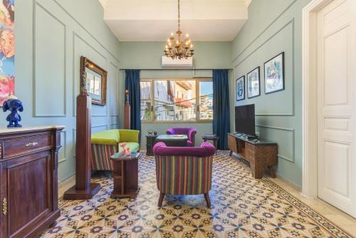 a living room with chairs and a tv at 961 Station Apartments in Mar Mikhael in Beirut