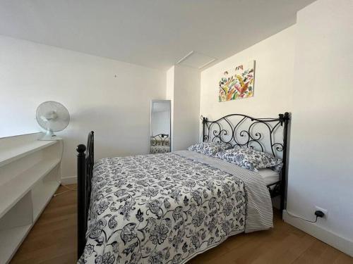 a bedroom with a bed with a black and white comforter at Les écuries du Roi - Château de Fontainebleau in Fontainebleau