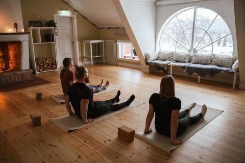 a group of people sitting on the floor in a living room at STF Undersvik Gårdshotell & Vandrarhem in Vallsta
