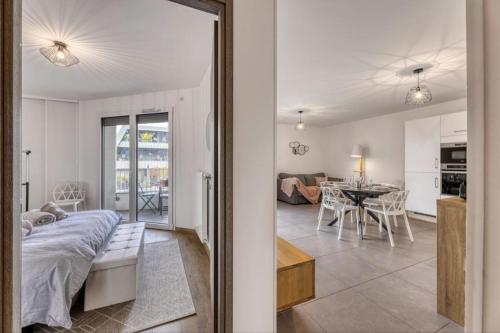 Cet appartement comprend une chambre avec un lit et un salon avec une table. dans l'établissement View Point Tresumvibes - OG IMMO, à Annecy