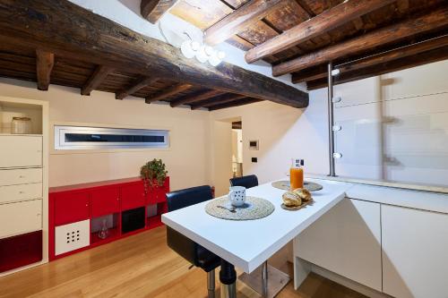 eine Küche mit einem weißen Tisch und roten Schränken in der Unterkunft iFlat Marvellous home near Via del Corso in Rom