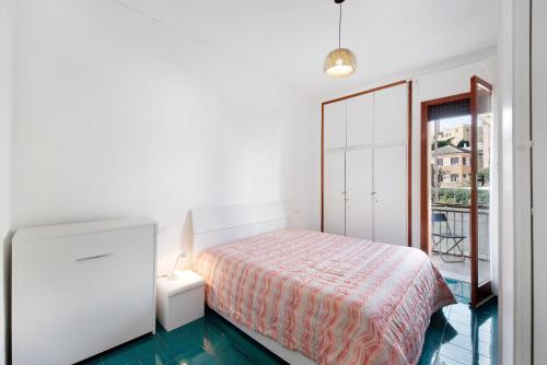 ein weißes Schlafzimmer mit einem Bett und einem Balkon in der Unterkunft Casa Sara in Arenzano