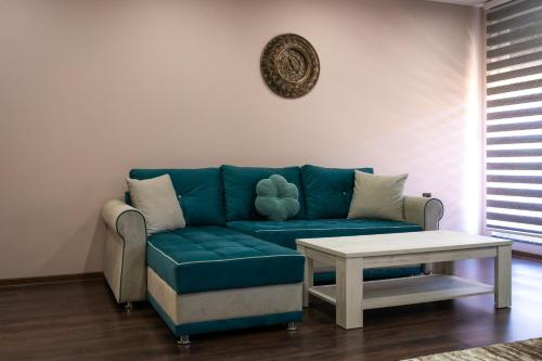 a living room with a blue couch and a table at Ema, Asja, Eda Apartments in Zenica
