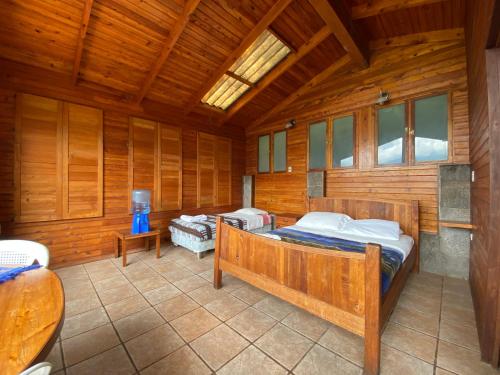 a bedroom with two beds in a wooden room at Lakefront Chalet in San Juan La Laguna