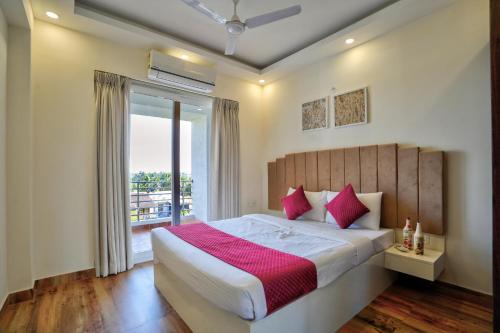 a bedroom with a large bed and a large window at Premium 2BHK Apartment with pool at Candolim Beach in Candolim