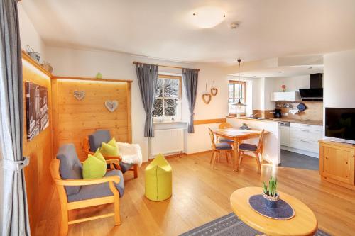 eine Küche und ein Wohnzimmer mit einem Tisch und Stühlen in der Unterkunft Ferienhof AllgäuMax in Füssen