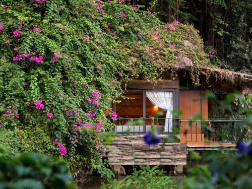 a house with pink flowers growing on it at Tam Coc Lion Kings Hotel & Resort in Ninh Binh