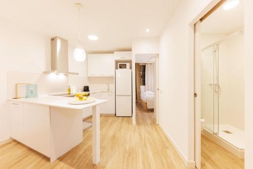 a kitchen with white cabinets and a white counter top at Bravissimo Auriga, Old town retreat in Girona
