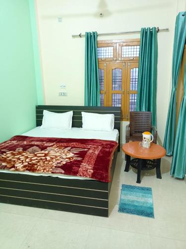 1 dormitorio con 1 cama grande y 1 mesa en Om Home Stay en Ayodhya