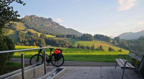 ein Fahrrad neben einer Bank mit einem Rucksack in der Unterkunft Jungholz Erlebnis in Jungholz