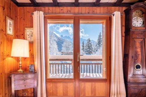 a room with a door and a window with a view at Spacious family chalet with balcony and garden in Chamonix