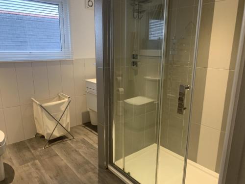 a bathroom with a glass shower with a toilet at Lovely one bedroom apartment in Llandudno