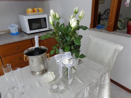 a table with a vase of white flowers on it at Apartments Butinar Pri Kapitanu in Ankaran