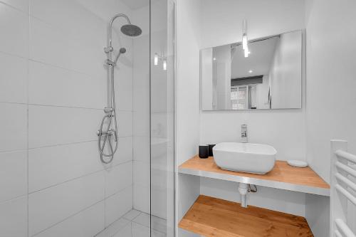 une salle de bain blanche avec un lavabo et une douche dans l'établissement Le Cosy - T2 hypercentre au calme avec Parking, à Toulouse
