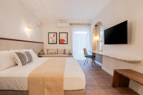 a hotel room with a bed and a tv at Blue Paradise Studios in Argostoli