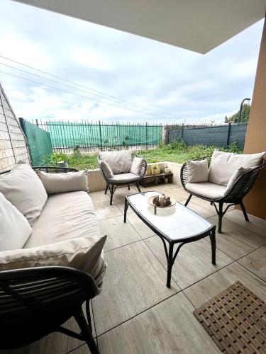 uma sala de estar com um sofá, cadeiras e uma mesa em Superbe appart avec Jardin à 2 min de l’Aéroport-4 pers em Vitrolles