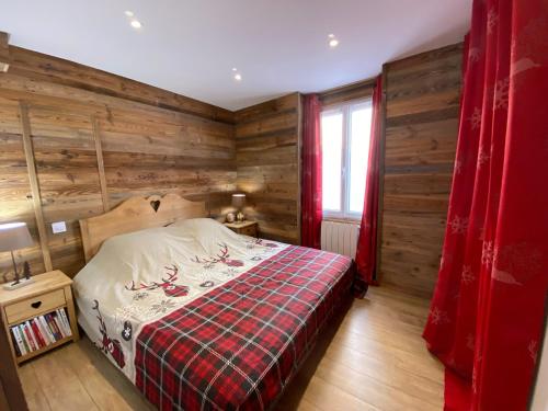 a bedroom with wooden walls and a bed and a window at Agréable 2 pièces isola village in Isola