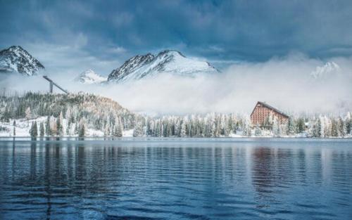 a view of a lake with snow covered mountains at Apartment 416 with mountain view in Hotel Crocus, Strbske Pleso in Štrbské Pleso