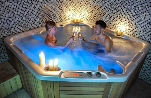a man and woman in a bath tub with candles at Apartment 416 with mountain view in Hotel Crocus, Strbske Pleso in Štrbské Pleso
