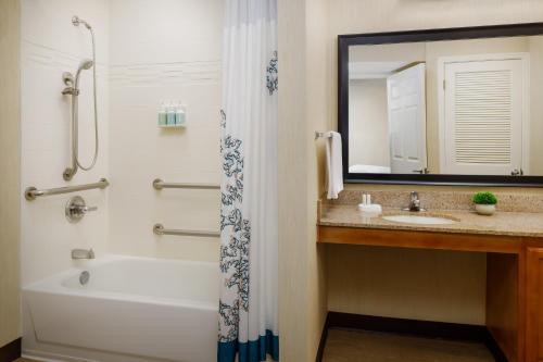 a bathroom with a tub and a sink and a mirror at Residence Inn Fremont Silicon Valley in Fremont