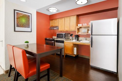 a kitchen with a table and a white refrigerator at Residence Inn Fremont Silicon Valley in Fremont