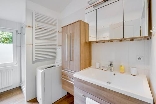 a white kitchen with a sink and a refrigerator at Meer & Wald Wellness Appartements in Heringsdorf