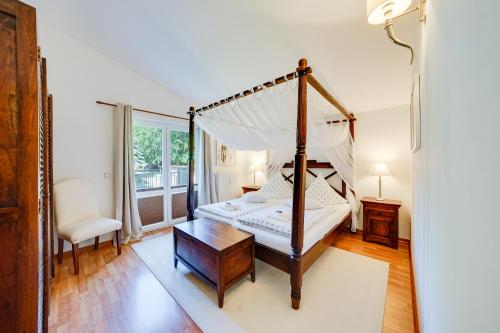 a bedroom with a canopy bed and a table at Meer & Wald Wellness Appartements in Heringsdorf