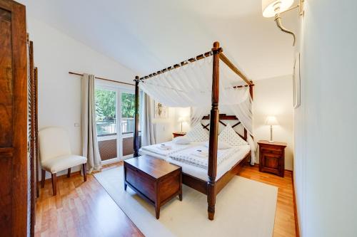 ein Schlafzimmer mit Himmelbett und Tisch in der Unterkunft Meer & Wald Wellness Appartements in Heringsdorf
