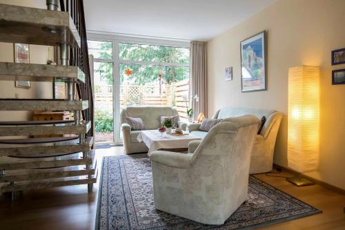 a living room with two chairs and a table at Ferienhaus an der Baeke D in Bad Zwischenahn