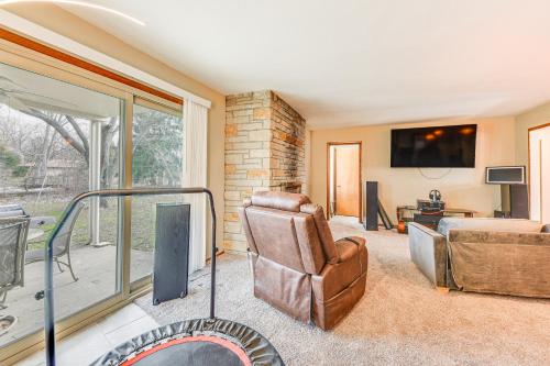 a living room with a chair and a couch and a tv at Convenient Racine Home 4 Mi to Lake Michigan! in Racine