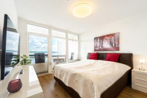 1 dormitorio con cama grande y ventana grande en Yachthafen am Delf, en Bad Zwischenahn