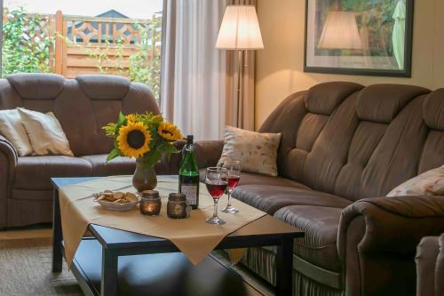 a living room with a couch and a table with wine glasses at Ferienhaus an der Baeke A in Bad Zwischenahn