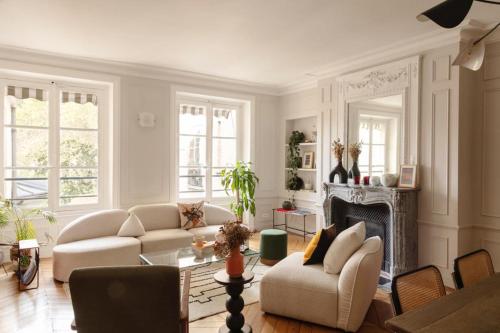 een woonkamer met witte meubels en een open haard bij luxury apartment saint germain des près Paris in Parijs