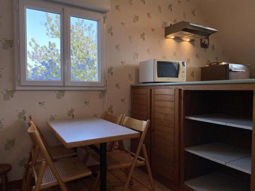 une petite cuisine avec une table et un micro-ondes dans l'établissement 609 - Appartement T3 au premier étage d'une maison à quelques pas de la plage et des commerces d'Erquy, à Erquy