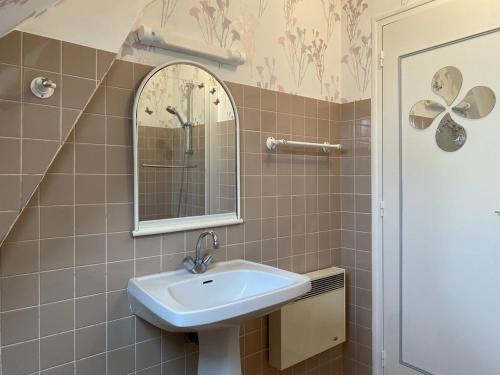 une salle de bain avec un lavabo et un miroir dans l'établissement 609 - Appartement T3 au premier étage d'une maison à quelques pas de la plage et des commerces d'Erquy, à Erquy