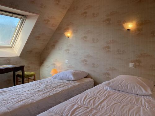 une chambre avec deux lits et un bureau et une fenêtre dans l'établissement 609 - Appartement T3 au premier étage d'une maison à quelques pas de la plage et des commerces d'Erquy, à Erquy