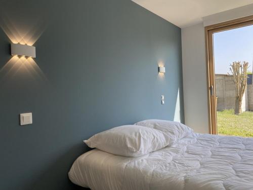 une chambre avec un lit blanc et une fenêtre dans l'établissement 608 - Maison deux chambres entièrement rénovée à quelques pas de la plage et du centre, à Erquy