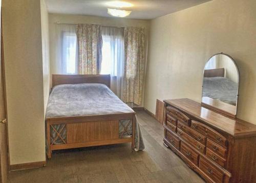 a bedroom with a bed and a dresser and a mirror at 3 Bed House in Niagara Falls in Niagara Falls