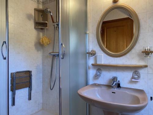 une salle de bain avec un lavabo et une douche avec un miroir dans l'établissement 661 - Charmante maison en pierre sur les Hauteurs d'Erquy avec vue mer, à Erquy
